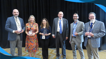 A picture of six people standing and holding awards.