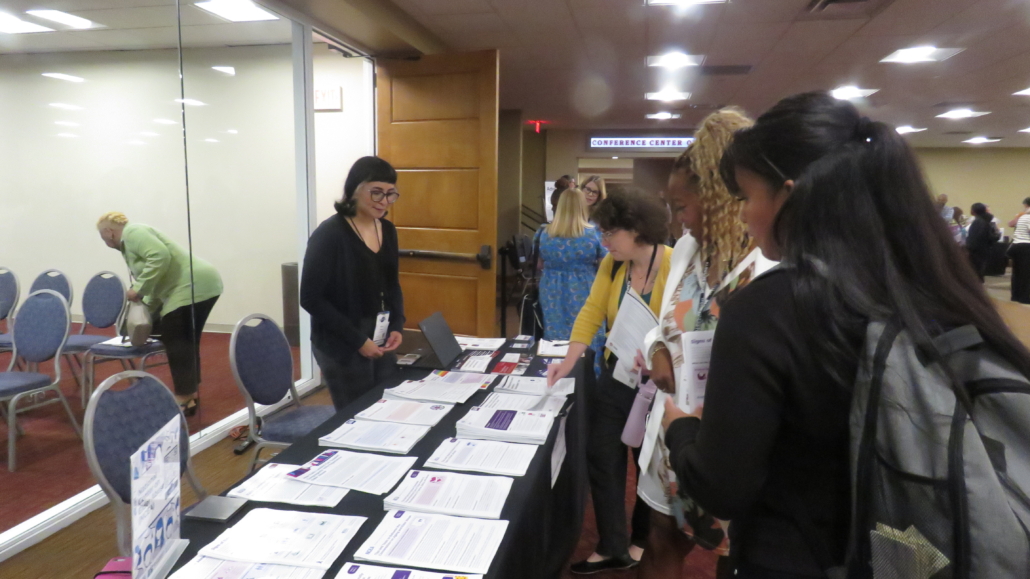 People at an exhibit booth getting more information at NAPSA annual conference.