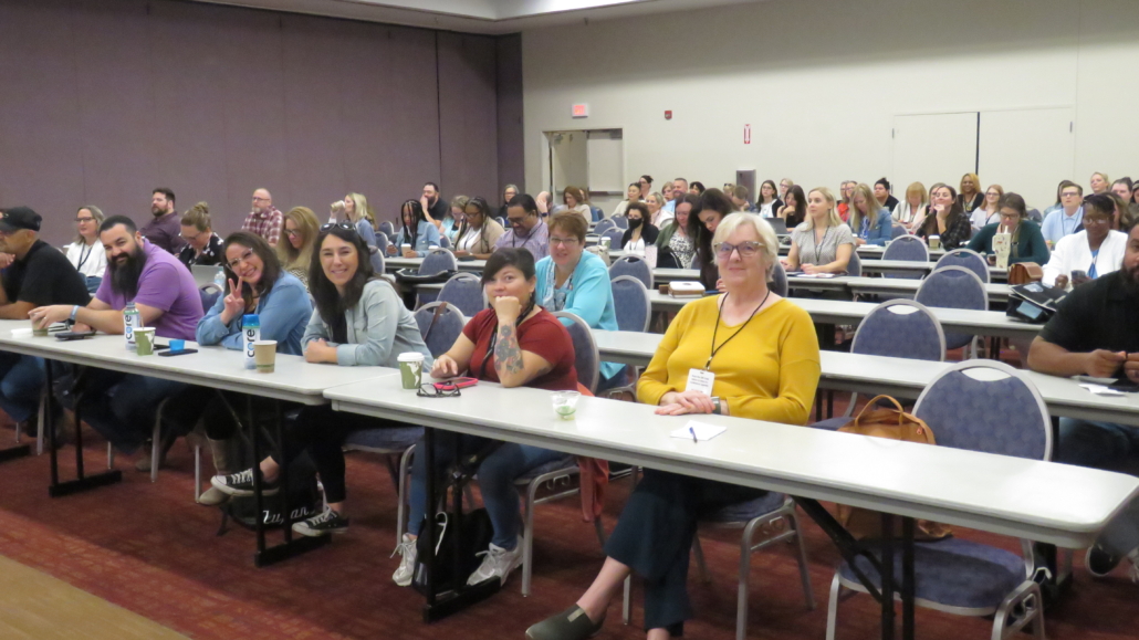 Large Conference room with long tables at Albuquerque National Conference, ready for a presenter to start.